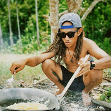 Skewers of marinated fish satay grilling over a campfire in Raja Ampat.