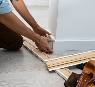 Mans hands putting white baseboard..jpg