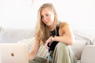 A woman works on a laptop in the comfort of her own home