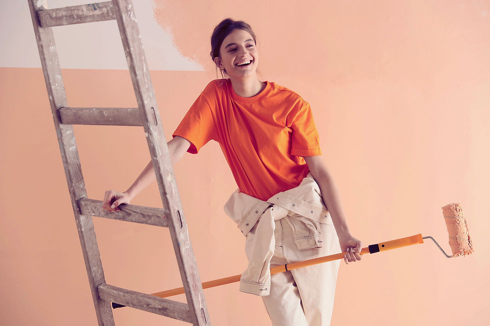 a girl smiling painting a wall