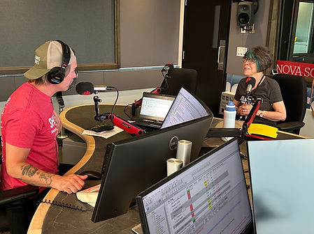 Halina seated at microphone in CBC radio studio with Mainstreet host Jeff Douglas