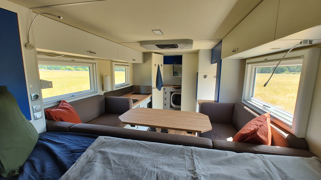 Wohnmobil-Innenraum: Bett, Sitzecke, Tisch