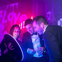 Attendees engaging with a glowing digital mirror photo booth by tradeshows by DMA events.