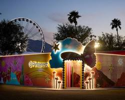 A vibrant Pinterest brand activation designed by DMA at Coachella, featuring a glowing entrance with a large butterfly and star motif, set against a twilight sky and the iconic festival Ferris wheel.