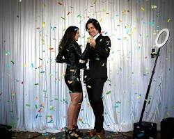 Charity event ideas featuring DMA interactive photo booth experience at a gala event with guests celebrating under confetti, highlighting branded event engagement and immersive fundraising activation.