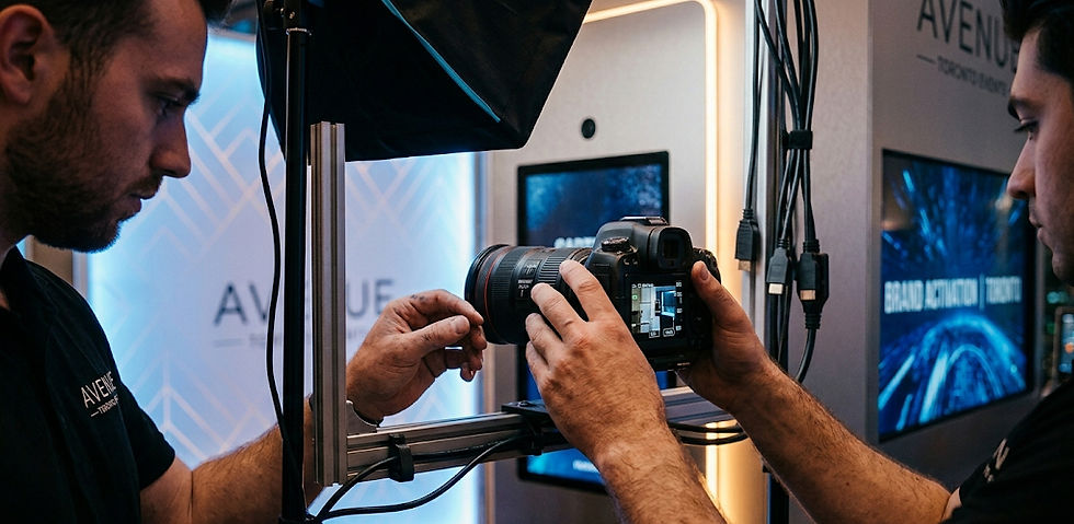 A behind-the-scenes close-up of a DMA technician meticulously adjusting a professional DSLR camera for a brand activation, with glowing digital screens and production lighting creating a focused, high-tech atmosphere.