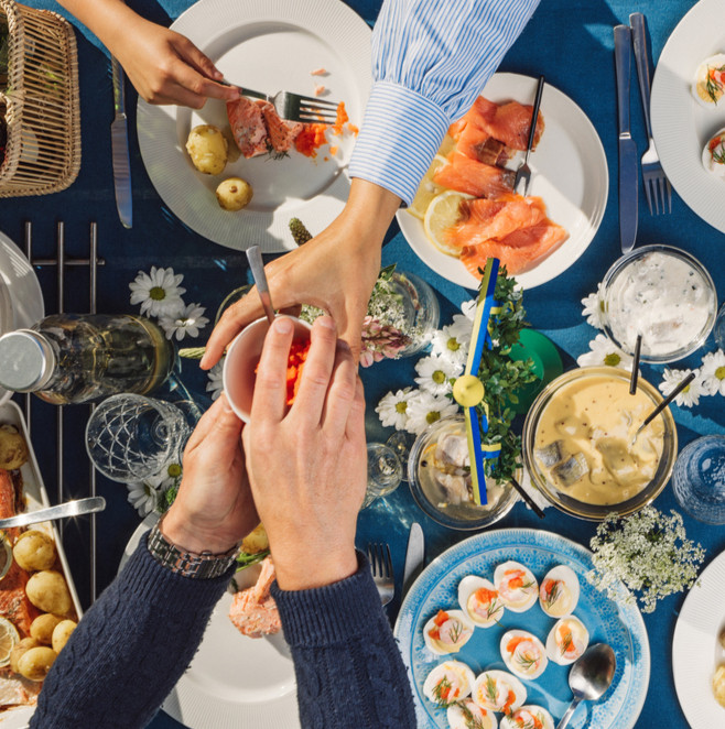 Hands passing food across a picnic table viewed from above