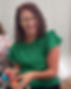 Nora smiles while holding Easter eggs, wearing a green dress