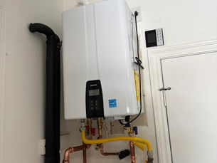 Navien tankless water heater professionally installed in San Clemente home by Clear Water Plumbing – clean copper piping and venting for reliable endless hot water