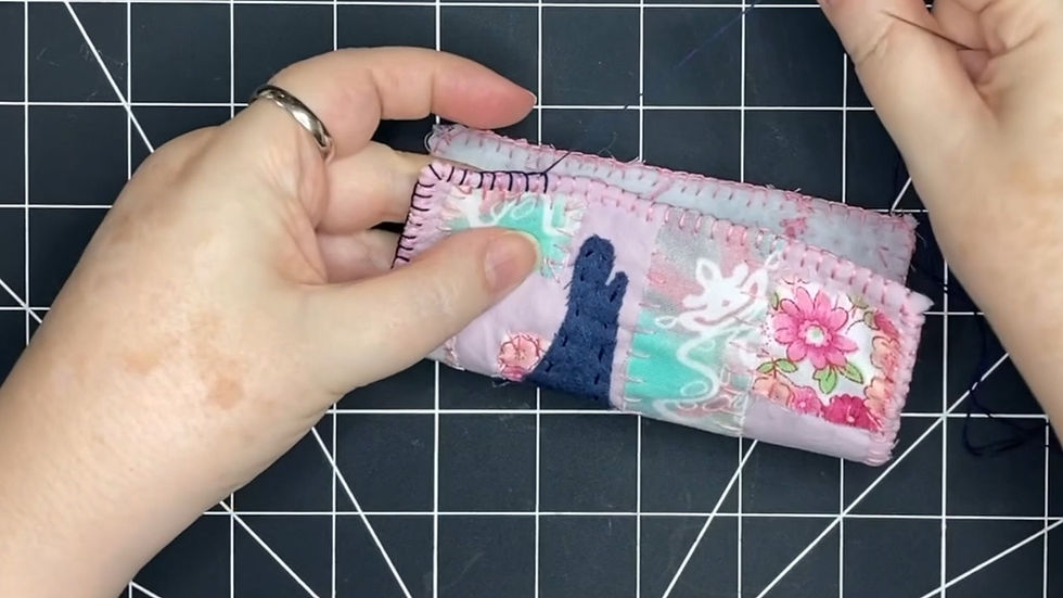 two hands sewing, one hand holding fabric, the other hold a needle