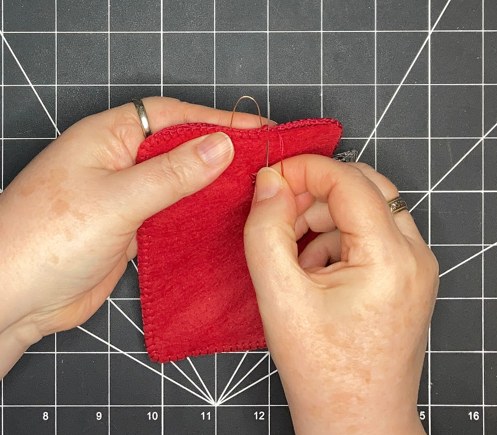 hand stitching closed the back of the textile art