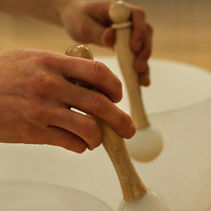 Woman playing Tibetan healing bowls during a sound therapy session