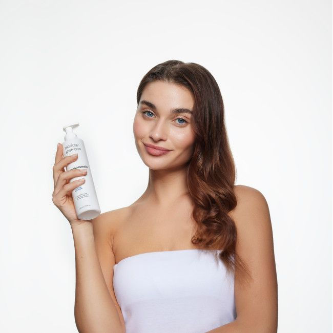 Thumbnail: Woman with product smiling, Haus Of Ästhetik in front of white background, holding dispenser.