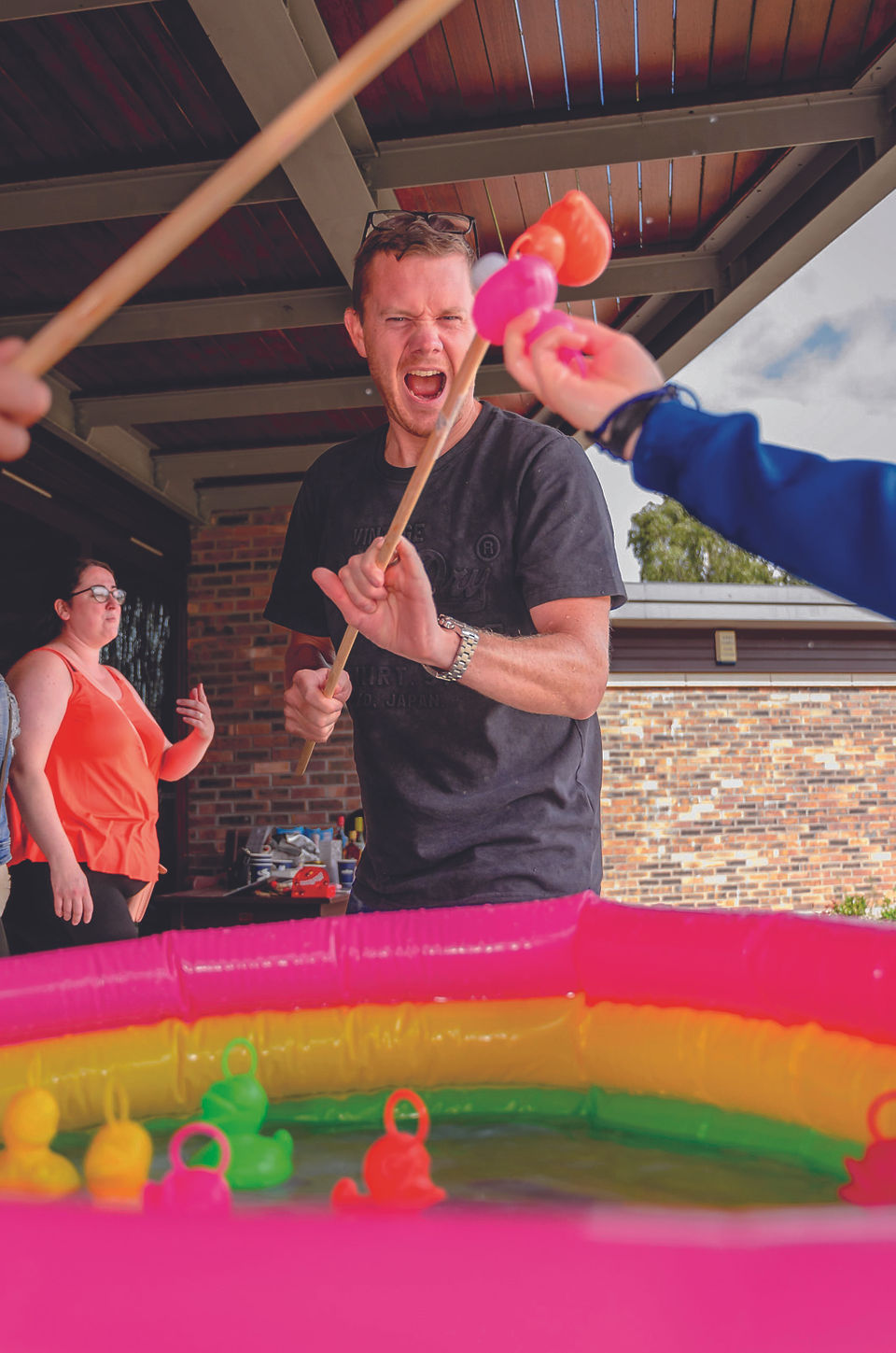 A man is happy that he's hooked a rubber duck on a stick.