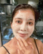 woman with a thick creamy skincare mask with citylights in the background
