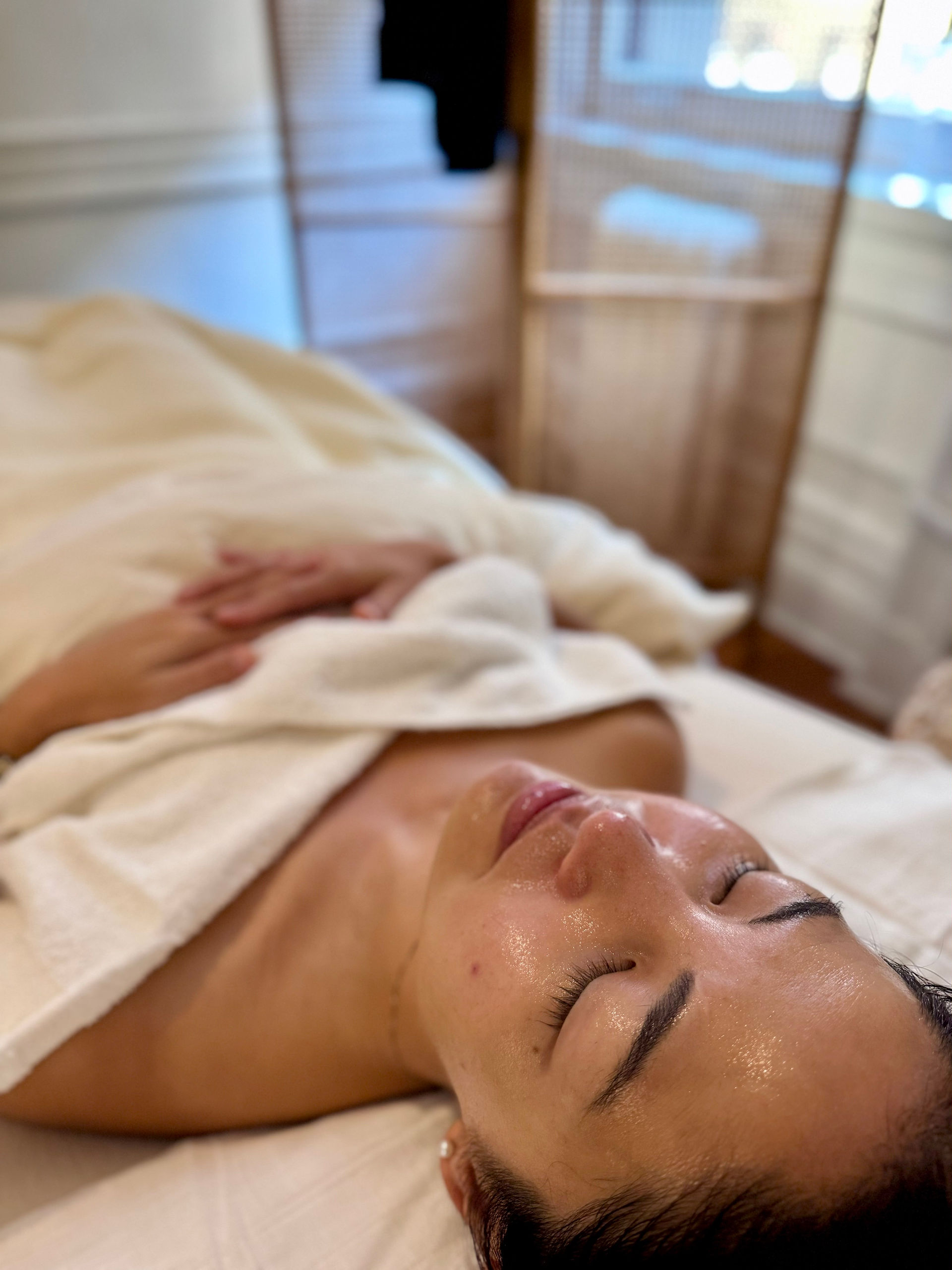 Woman relaxing on a treatment bed during a facial