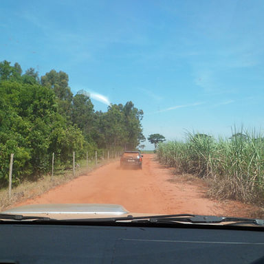 estrada de terra, carro na estrada de terra, trilhas do brasil, viagens de aventura, explorando o mundo, viver intensamente, parabrisa de carro na estrada, céu azul, planejar viagens, viagem em comboio, combio de viagem, comboio na estrada