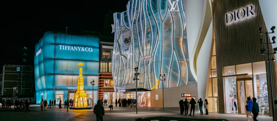 Brand recognition through iconic luxury brand storefronts at night.