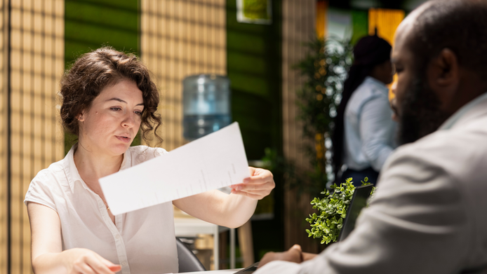 A woman holding a paper telling how to write a business proposal letter for funding.