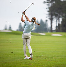 Woman golfing as a way to find balance outside of therapy.