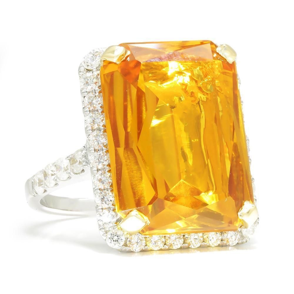 large emerald cut citrine and diamond halo white gold cocktail ring on a white background