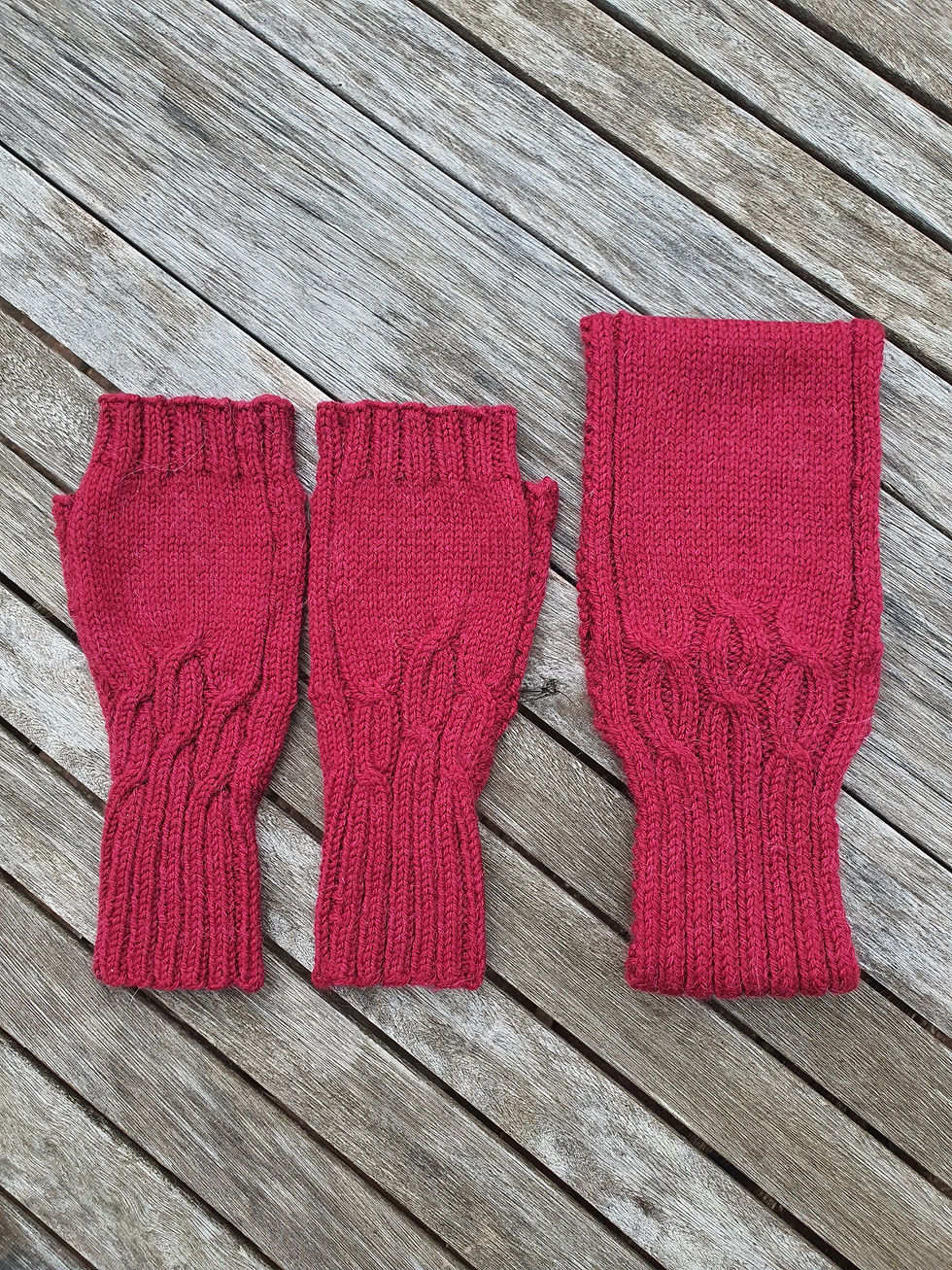 Pair of deep red cable knitted fingerless gloves and matching headband lying on a weathered grey wooden slatted table.