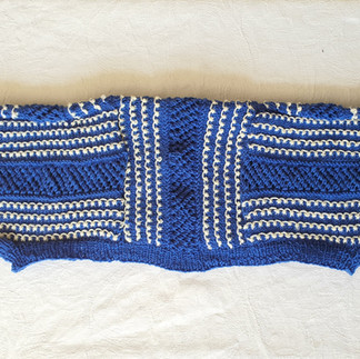 a blue and white knitted shrug, folded