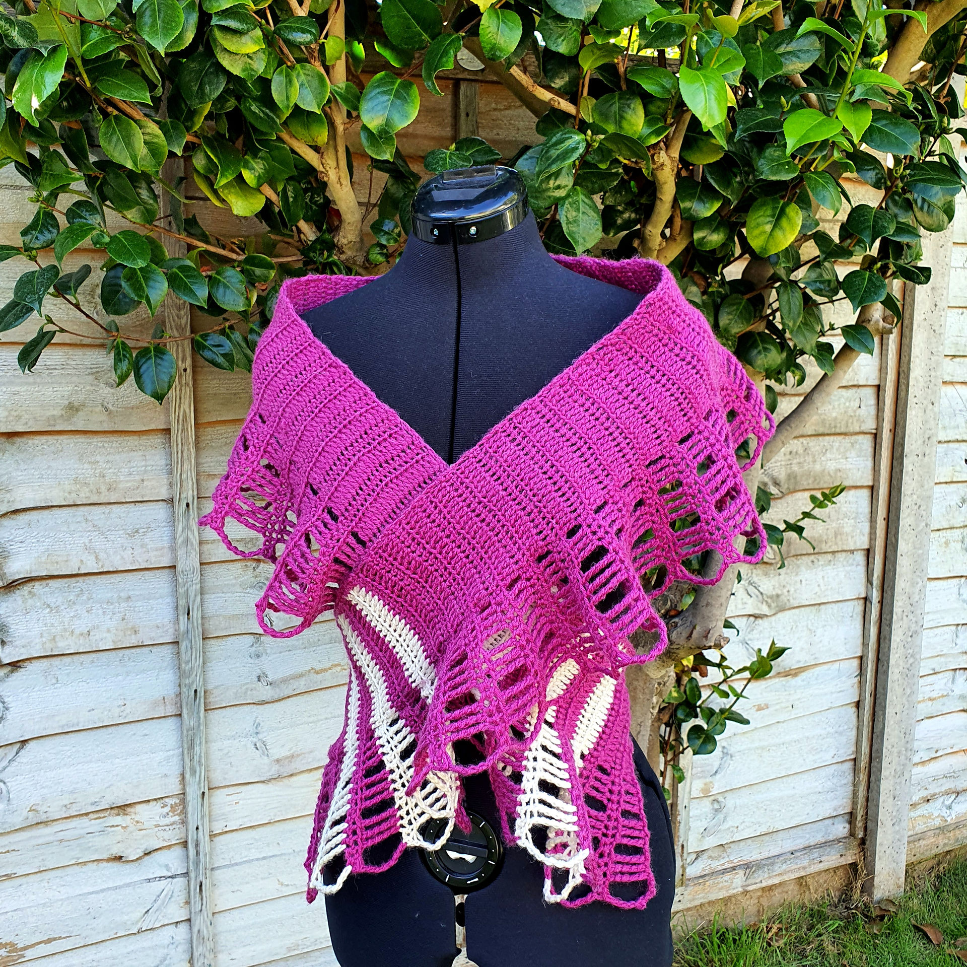 Clarion Multiway Scarf in brighte pink made of a straight panel with a ruffled edge wrapped around the shoulders and across the chest like a top