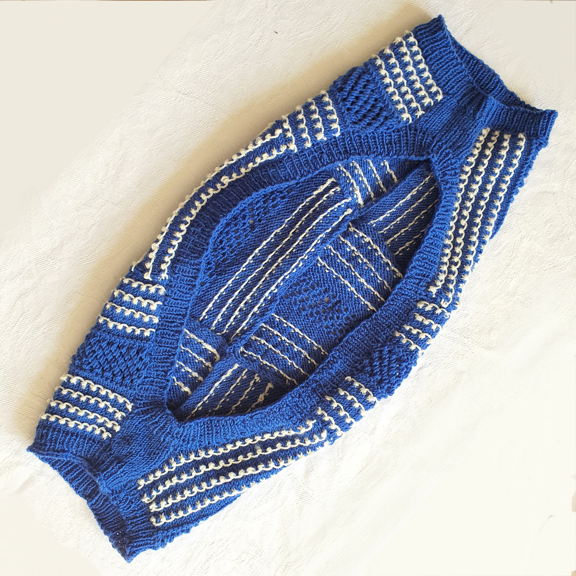 a blue and white knitted shrug, inside showing