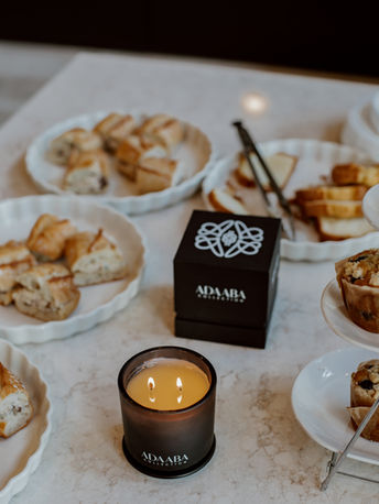 black luxury candle set in the midst of pastries