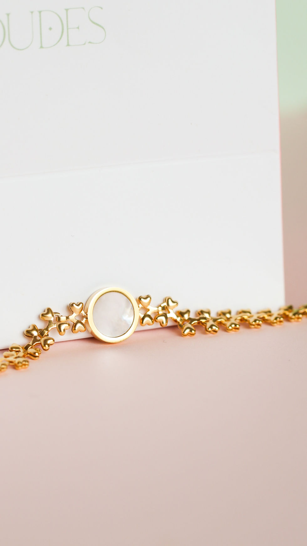 Miniatura: Pulsera dorada con nácar sobre fondo minimalista estilo lujo