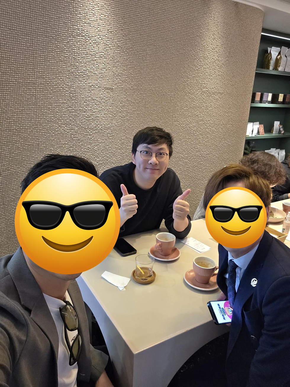 Photo of consultant meeting with clients at a cafe, casual business setting, warm colors, landscape.