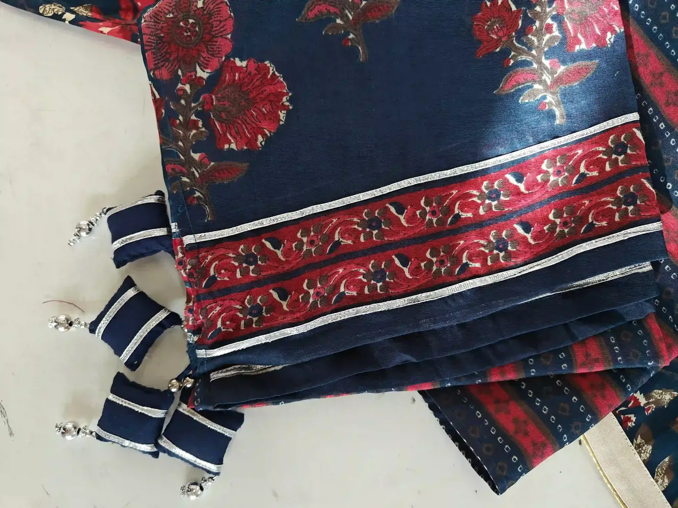 A kurti featuring custom latkan designs on the placket and personalized potli work on the dupatta.