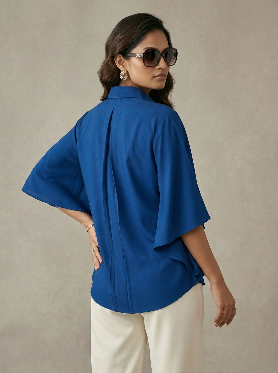 Model wearing Royal Blue Collared Kaftan Top with cream pants and heels