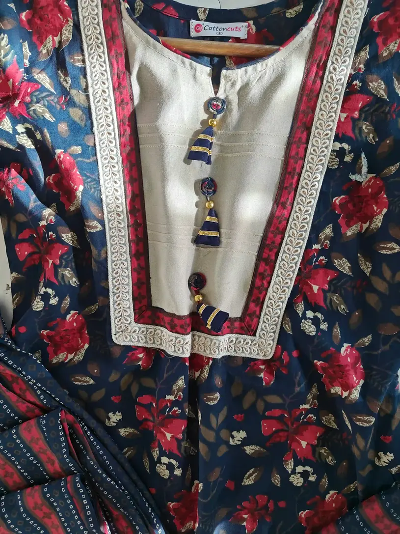 A kurti featuring custom latkan designs on the placket and personalized potli work on the dupatta.