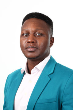 Portrait en studio d’un homme en veste turquoise et chemise blanche sur fond blanc.