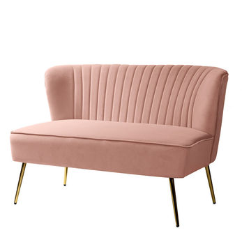 Blush pink velvet loveseat with a curved, ribbed backrest and gold metal legs, available for rent from Bubbles Luxury Rentals. Perfect for adding a touch of elegance and modern style to events such as weddings and bridal showers."