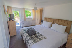 Bedroom 4 with Wardrobes, Bedside Tables, TV, and Patio Access