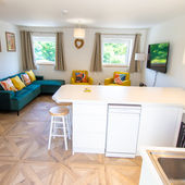 Open plan living area featuring a wall-mounted TV and breakfast bar, perfect for casual meals.