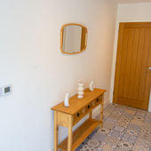 View of the entrance hall’s sideboard and mirror, leading to Bedroom 1 at Villa No. 3.