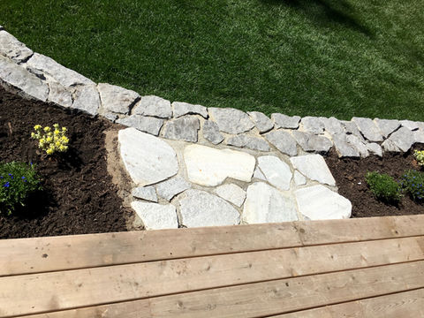 Cedar deck with stone retaining walls, studio outbuilding and lawn 