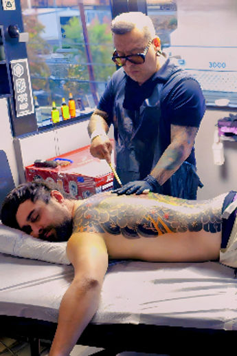 man standing performing traditional Japanese Tebori Tattoo