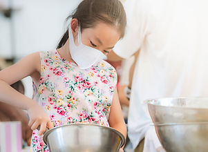 Asian child girl in cooking workshop for kid, holding kitchen equipment, wearing protectiv