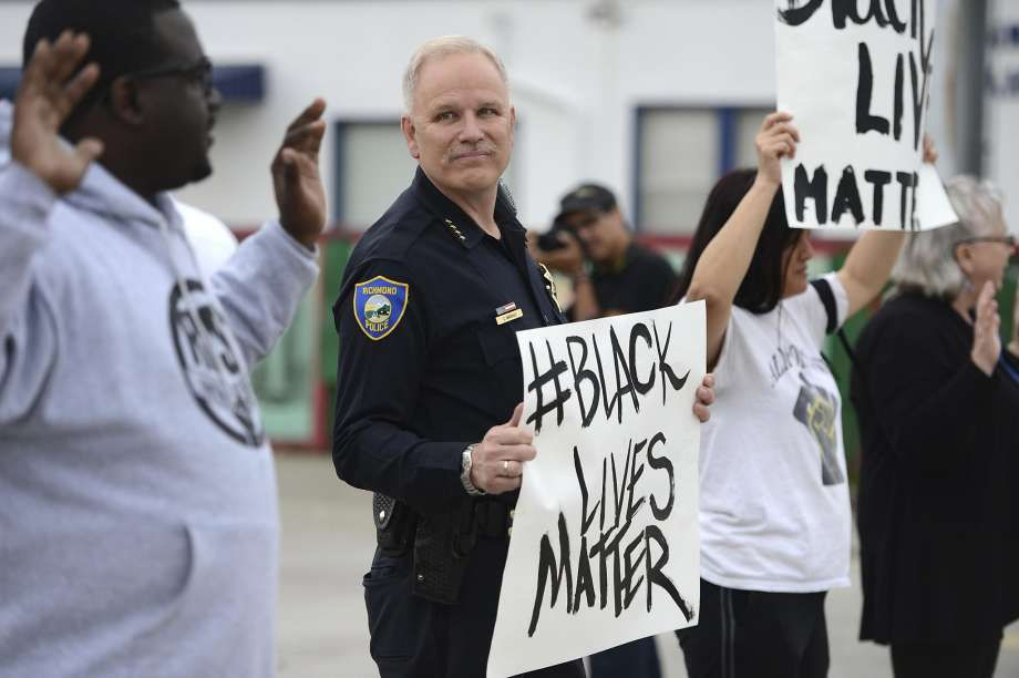 police hold 'Black Lives Matter' sign during protest