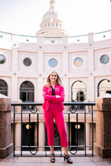 young girl in pink suit graduating with a political degree at the Austin state captial 