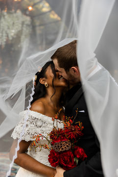 Bride and groom sharing a romantic kiss under the veil