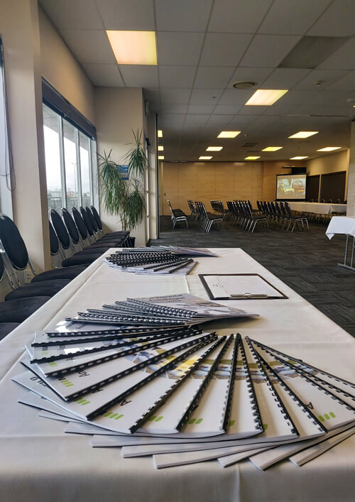 Brochures arranged on a table in an empty event conference room.
