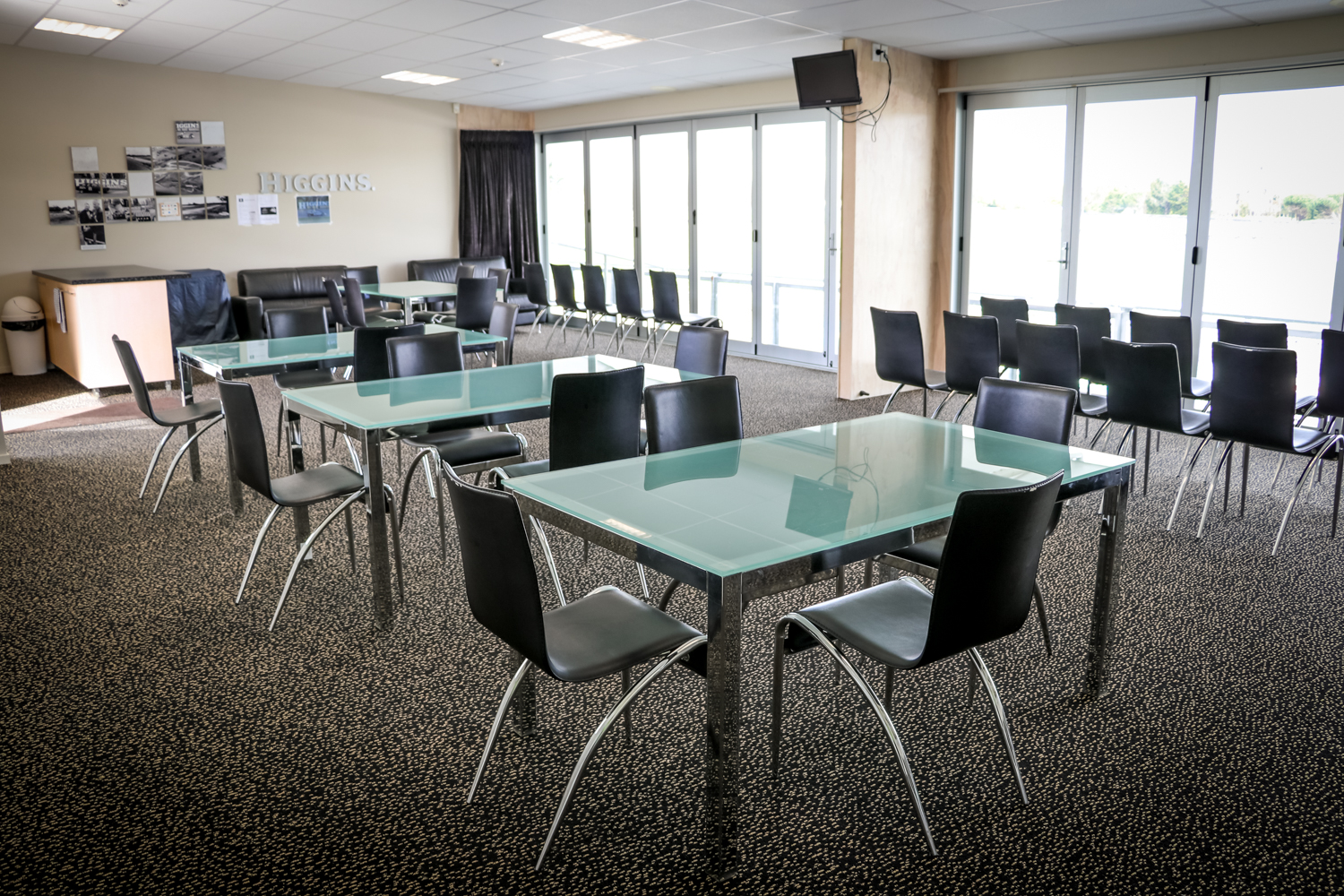 Spacious meeting room with glass tables, black chairs, and large windows.