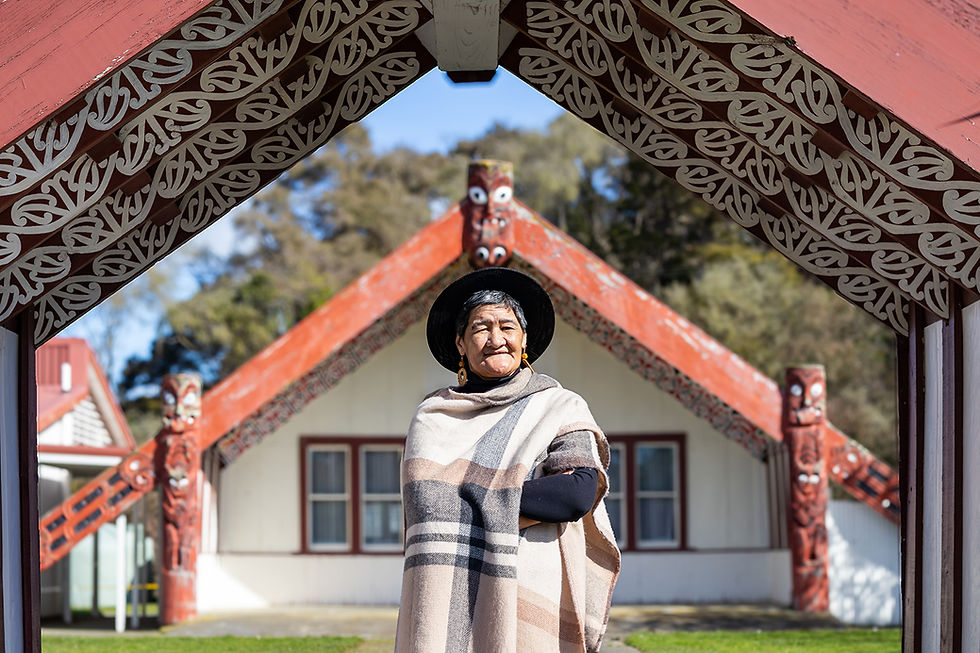 Māori woman in traditional cloak at a Marae meeting house