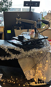Festive standing desk setup with computer and lights